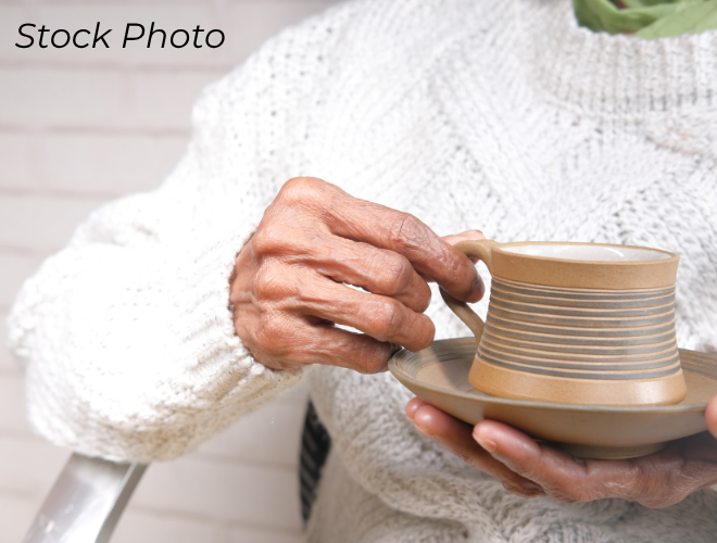 Elderly woman holding a cup of coffee